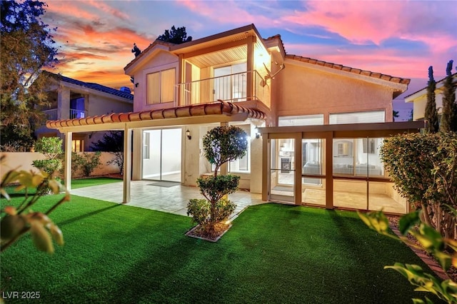 7837 Sea Rock Rd, Las Vegas, NV 89128 - back of property at dusk featuring a patio, a tile roof, a balcony, and stucco siding