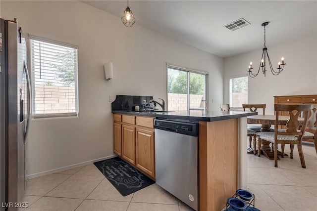 3936 Pepper Thorn Ave Unit 3, North Las Vegas, NV 89081 - kitchen featuring appliances with stainless steel finishes, dark countertops, light tile patterned flooring, a peninsula, and a chandelier