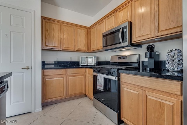 3936 Pepper Thorn Ave Unit 3, North Las Vegas, NV 89081 - kitchen with appliances with stainless steel finishes, light tile patterned flooring, and dark stone counters