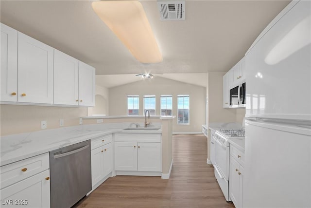 10001 Peace Way Unit 2322, Las Vegas, NV 89147 - kitchen with white appliances, a peninsula, light wood-style floors, white cabinetry, and lofted ceiling