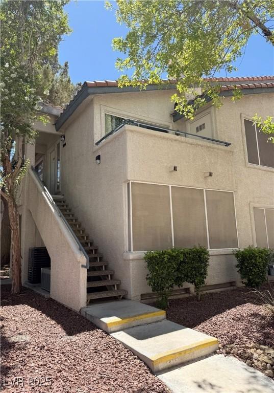 3055 Key Largo Dr Unit 204, Las Vegas, NV 89120 - view of property exterior featuring stairway, stucco siding, and a tiled roof