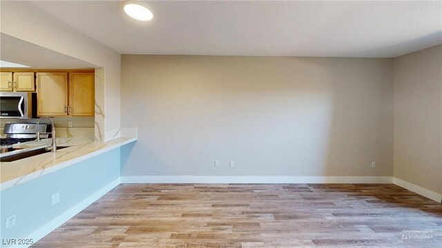 8070 W Russell Rd Unit 1046, Las Vegas, NV 89113 - kitchen with stainless steel appliances, light wood-style floors, and light stone counters