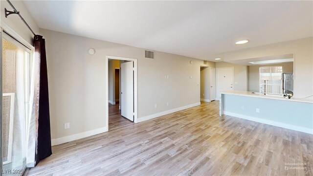 8070 W Russell Rd Unit 1046, Las Vegas, NV 89113 - unfurnished living room with healthy amount of natural light, light wood-style floors, and recessed lighting