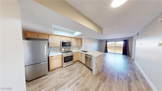 8070 W Russell Rd Unit 1046, Las Vegas, NV 89113 - kitchen featuring stainless steel appliances, light brown cabinetry, a peninsula, light wood finished floors, and light countertops