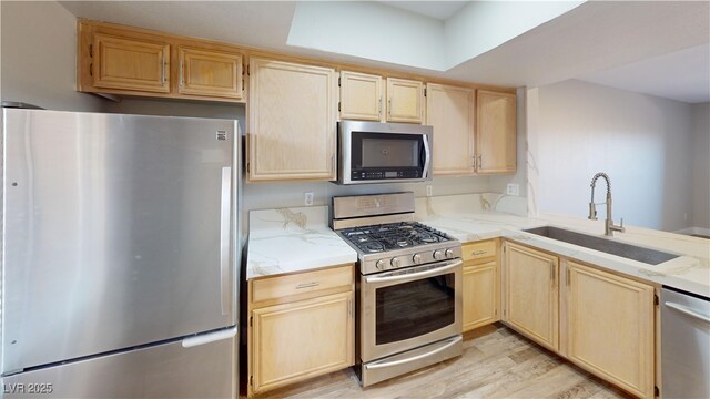 8070 W Russell Rd Unit 1046, Las Vegas, NV 89113 - kitchen featuring appliances with stainless steel finishes, light brown cabinetry, light stone counters, and light wood-style flooring