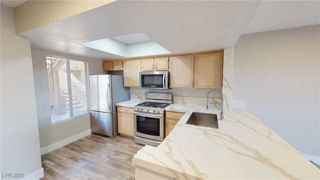 8070 W Russell Rd Unit 1046, Las Vegas, NV 89113 - kitchen with stainless steel appliances, light stone counters, light brown cabinets, and light wood finished floors
