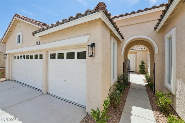 2297 Aria Dr, Henderson, NV 89052 - view of side of property with stucco siding, a tile roof, concrete driveway, and a garage