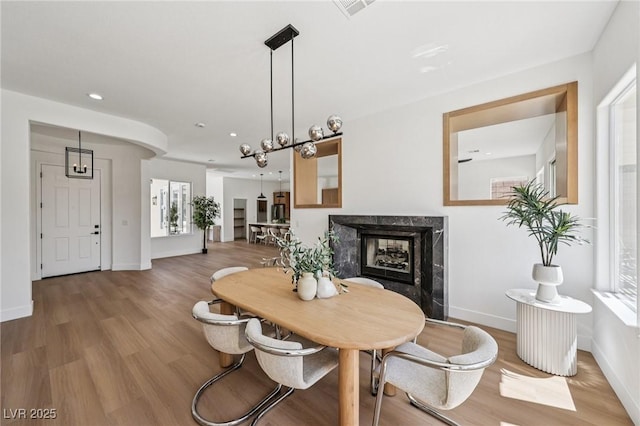 2297 Aria Dr, Henderson, NV 89052 - dining area featuring a premium fireplace, wood finished floors, recessed lighting, and plenty of natural light