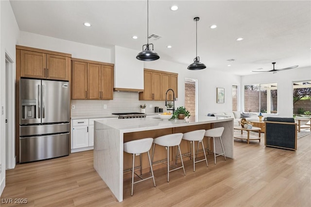 2297 Aria Dr, Henderson, NV 89052 - kitchen featuring stainless steel refrigerator with ice dispenser, recessed lighting, light wood-type flooring, tasteful backsplash, and custom exhaust hood