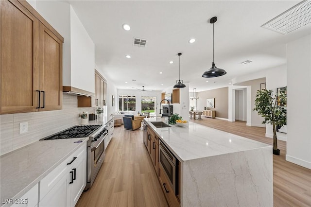 2297 Aria Dr, Henderson, NV 89052 - kitchen featuring open floor plan, appliances with stainless steel finishes, recessed lighting, tasteful backsplash, and light wood-type flooring