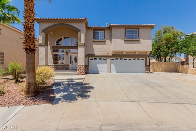 1054 Broomfield Dr, Henderson, NV 89074 - mediterranean / spanish-style house featuring an attached garage, stucco siding, concrete driveway, stone siding, and a tiled roof