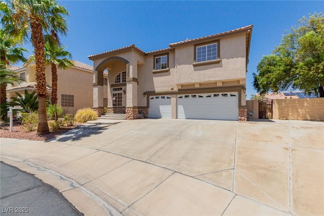 1054 Broomfield Dr, Henderson, NV 89074 - mediterranean / spanish-style home featuring stucco siding, an attached garage, driveway, stone siding, and a tiled roof