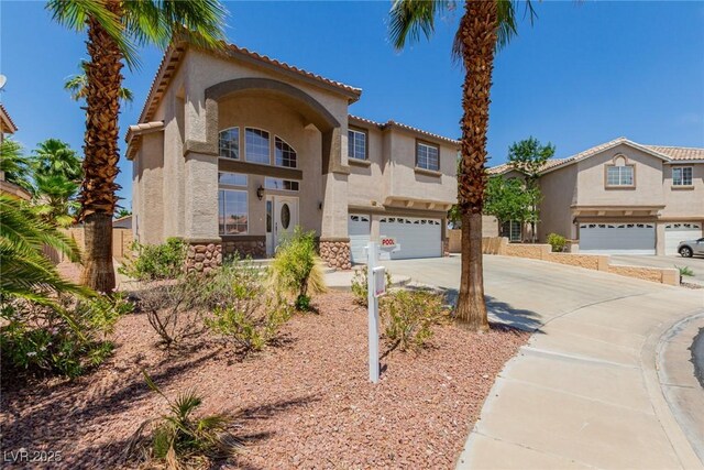 1054 Broomfield Dr, Henderson, NV 89074 - mediterranean / spanish home with a garage, concrete driveway, stucco siding, and stone siding