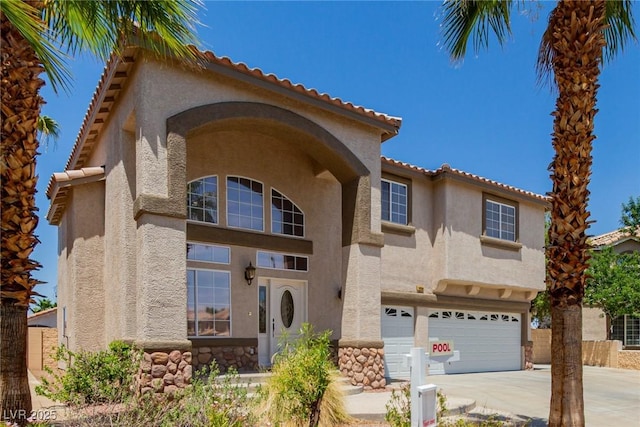1054 Broomfield Dr, Henderson, NV 89074 - view of front facade with stucco siding, an attached garage, concrete driveway, stone siding, and a tiled roof