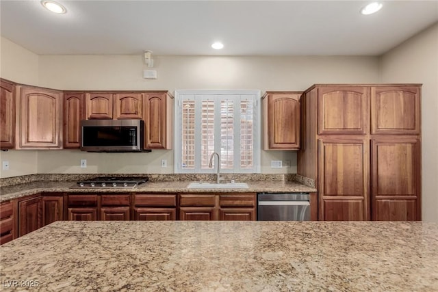 1054 Broomfield Dr, Henderson, NV 89074 - kitchen with appliances with stainless steel finishes, recessed lighting, brown cabinetry, and light stone countertops