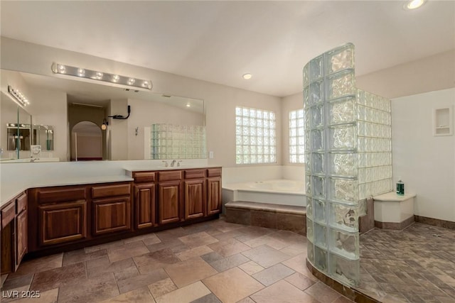 1054 Broomfield Dr, Henderson, NV 89074 - bathroom with a garden tub, vanity, stone tile floors, walk in shower, and recessed lighting