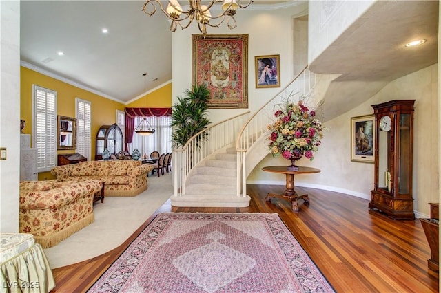 7889 Rancho Mirage Dr, Las Vegas, NV 89113 - entrance foyer featuring a chandelier, wood finished floors, high vaulted ceiling, stairway, and crown molding