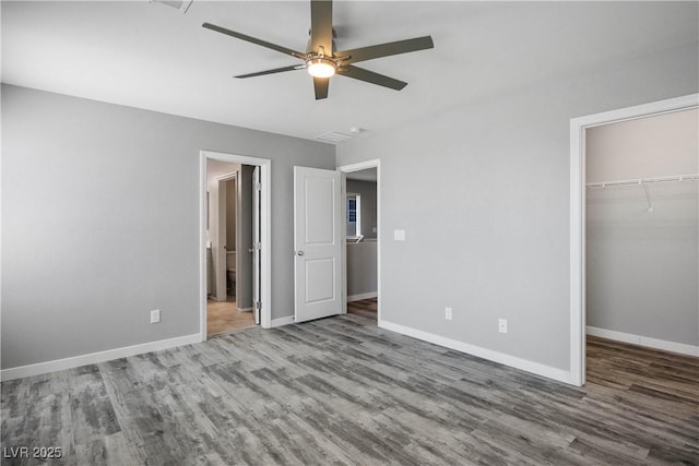 7990 Formitch Ct, Las Vegas, NV 89166 - unfurnished bedroom with wood finished floors, a walk in closet, a closet, and ceiling fan