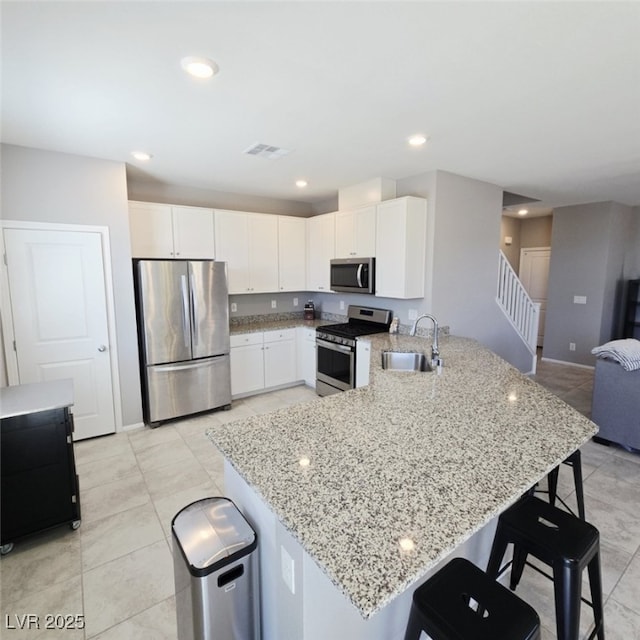 7990 Formitch Ct, Las Vegas, NV 89166 - kitchen featuring stainless steel appliances, a peninsula, open floor plan, a breakfast bar, and recessed lighting