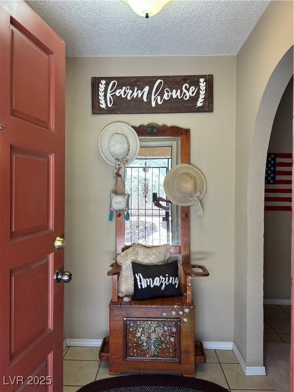 1866 Camino Verde Ln, Las Vegas, NV 89119 - foyer entrance featuring arched walkways, light tile patterned flooring, and a textured ceiling