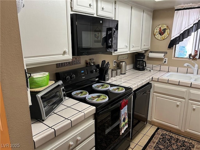 1866 Camino Verde Ln, Las Vegas, NV 89119 - kitchen with black appliances, tile countertops, white cabinets, and light tile patterned floors