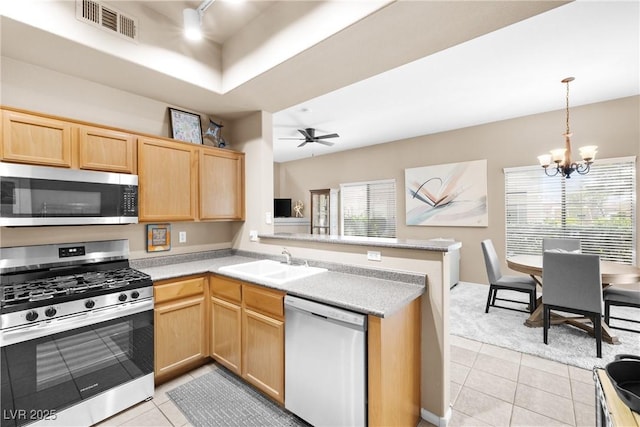 3451 Desert Cliff St Unit 103, Las Vegas, NV 89129 - kitchen featuring appliances with stainless steel finishes, light brown cabinets, light tile patterned floors, and a peninsula