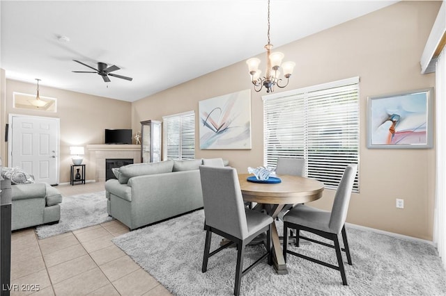 3451 Desert Cliff St Unit 103, Las Vegas, NV 89129 - dining room with a chandelier, a tiled fireplace, ceiling fan, and light tile patterned floors