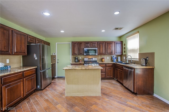 9022 Sosa Creek Ave, Las Vegas, NV 89149 - kitchen featuring stainless steel appliances, decorative backsplash, a kitchen island, light wood-style floors, and recessed lighting