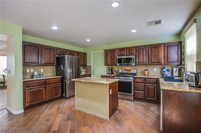 9022 Sosa Creek Ave, Las Vegas, NV 89149 - kitchen with appliances with stainless steel finishes, wood finished floors, tasteful backsplash, healthy amount of natural light, and recessed lighting