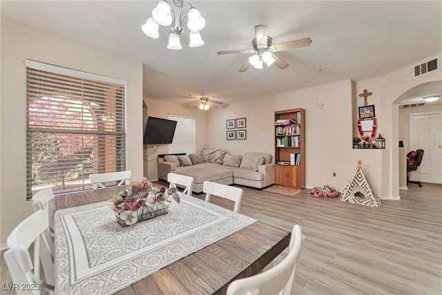 3975 N Hualapai Way Unit 121, Las Vegas, NV 89129 - dining space with arched walkways, light wood-style flooring, ceiling fan, and a chandelier