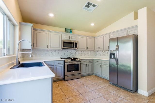 6740 Arctic Breeze St, North Las Vegas, NV 89084 - kitchen with appliances with stainless steel finishes, decorative backsplash, light tile patterned flooring, light countertops, and lofted ceiling
