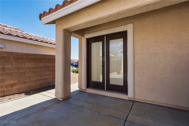 6740 Arctic Breeze St, North Las Vegas, NV 89084 - view of exterior entry with a patio area, stucco siding, and a tile roof