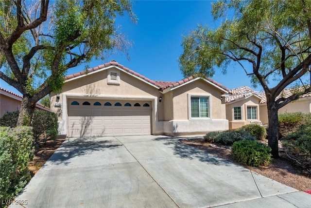 6740 Arctic Breeze St, North Las Vegas, NV 89084 - mediterranean / spanish-style house featuring stucco siding, a tiled roof, an attached garage, and concrete driveway