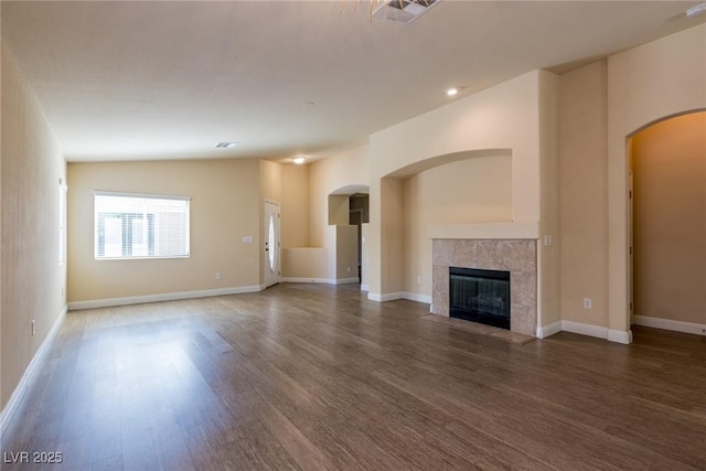 6740 Arctic Breeze St, North Las Vegas, NV 89084 - unfurnished living room featuring arched walkways, wood finished floors, and a tile fireplace