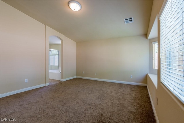 6740 Arctic Breeze St, North Las Vegas, NV 89084 - carpeted empty room with arched walkways, plenty of natural light, and vaulted ceiling