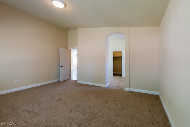 6740 Arctic Breeze St, North Las Vegas, NV 89084 - unfurnished bedroom featuring light colored carpet, arched walkways, a walk in closet, and lofted ceiling
