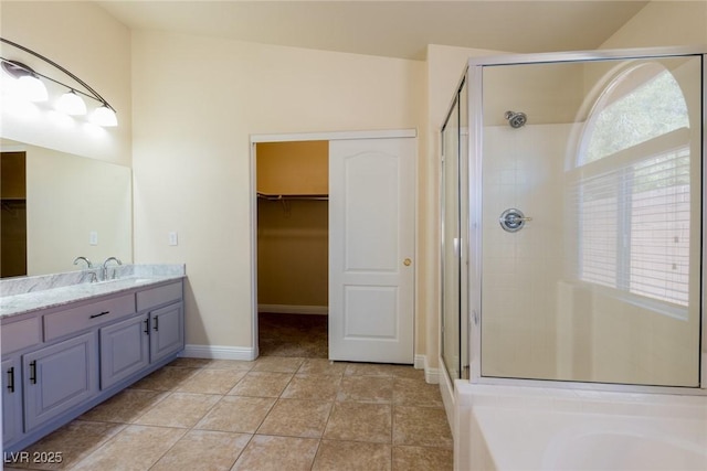 6740 Arctic Breeze St, North Las Vegas, NV 89084 - bathroom featuring a walk in closet, a stall shower, vanity, tile patterned flooring, and a garden tub