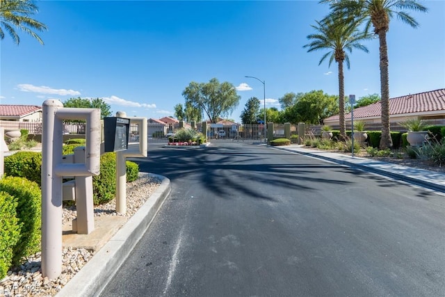 6740 Arctic Breeze St, North Las Vegas, NV 89084 - view of asphalt street featuring street lighting, a gate, curbs, a gated entry, and a residential view