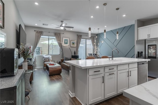 2530 Catallo St, Henderson, NV 89044 - kitchen featuring appliances with stainless steel finishes, dark wood-style floors, a ceiling fan, a kitchen island with sink, and white cabinets