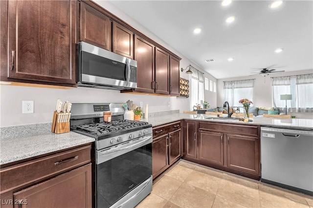 4332 Stardusk Falls Ave, North Las Vegas, NV 89084 - kitchen featuring stainless steel appliances, recessed lighting, dark brown cabinets, ceiling fan, and light stone counters