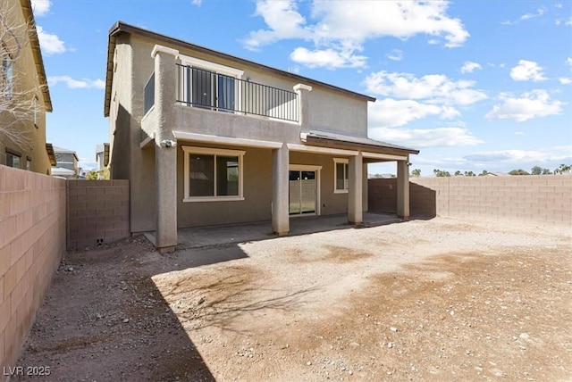 9268 Wildfire Gorge St, Las Vegas, NV 89139 - rear view of house with a balcony, a fenced backyard, a patio, and stucco siding