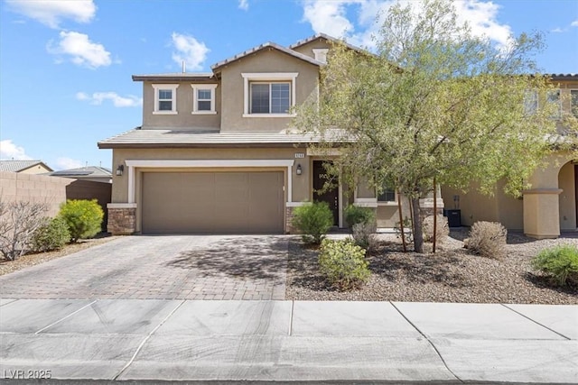 9268 Wildfire Gorge St, Las Vegas, NV 89139 - view of front of home featuring stucco siding, driveway, an attached garage, and stone siding