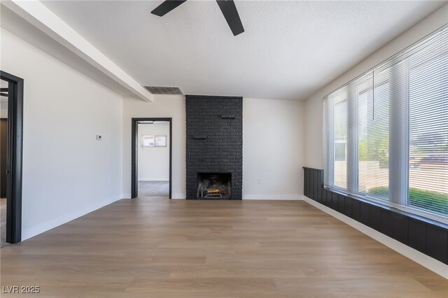 5617 Alfred Dr, Las Vegas, NV 89108 - unfurnished living room featuring ceiling fan, light wood-style flooring, and a fireplace