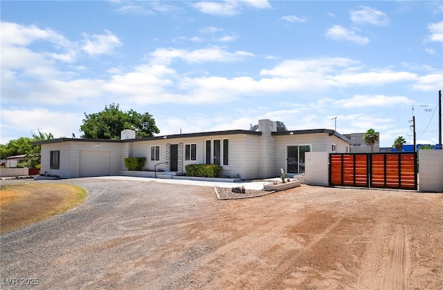 5617 Alfred Dr, Las Vegas, NV 89108 - view of front of home with dirt driveway, an attached garage, and a gate
