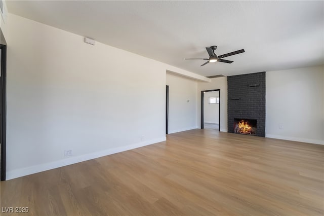 5617 Alfred Dr, Las Vegas, NV 89108 - unfurnished living room featuring light wood finished floors, ceiling fan, and a brick fireplace