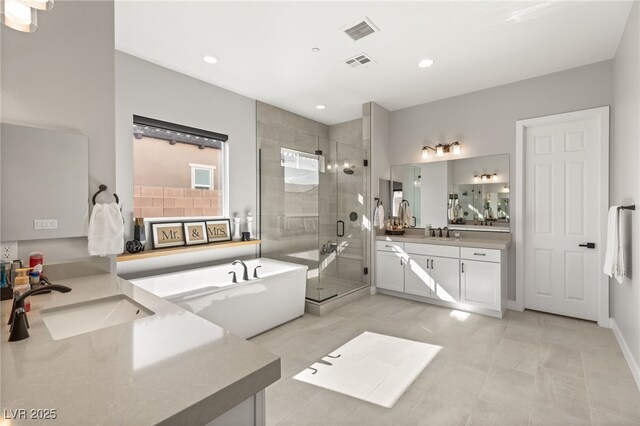 8575 Nicholas James Ave, Las Vegas, NV 89143 - bathroom with two vanities, a stall shower, a freestanding bath, recessed lighting, and tile patterned floors