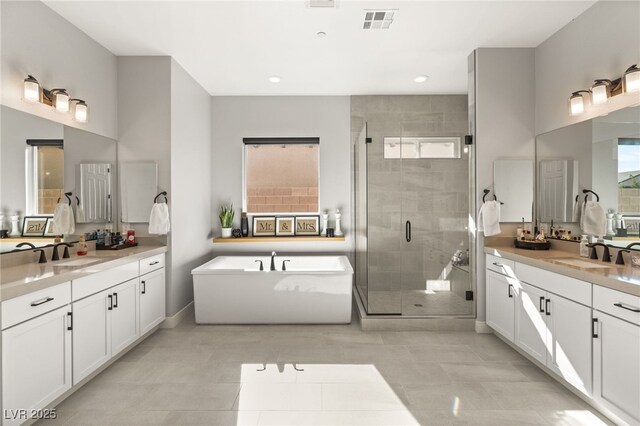 8575 Nicholas James Ave, Las Vegas, NV 89143 - full bathroom featuring two vanities, a stall shower, a soaking tub, recessed lighting, and tile patterned floors