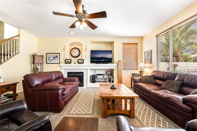 532 Kavanagh Pl, Las Vegas, NV 89123 - living area with carpet floors, a ceiling fan, a glass covered fireplace, and stairs