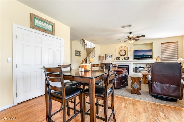 532 Kavanagh Pl, Las Vegas, NV 89123 - dining space with ceiling fan, light wood finished floors, stairs, and a fireplace