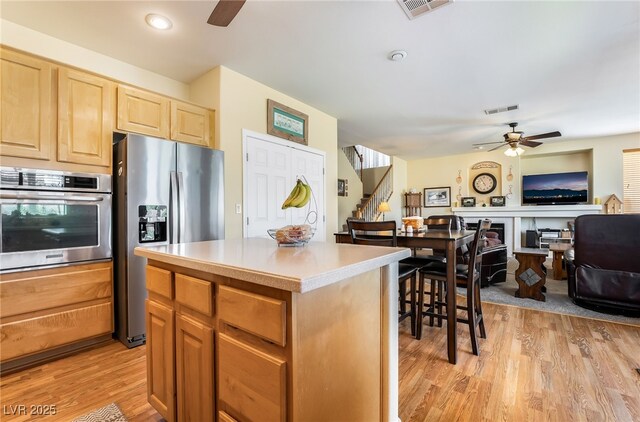 532 Kavanagh Pl, Las Vegas, NV 89123 - kitchen featuring stainless steel appliances, ceiling fan, light wood finished floors, light brown cabinets, and open floor plan